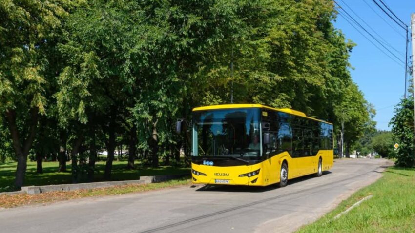 Автобусне сполучення у Солом’янському районі Жовтий міський автобус їде зеленою вулицею Києва у Солом’янському районі